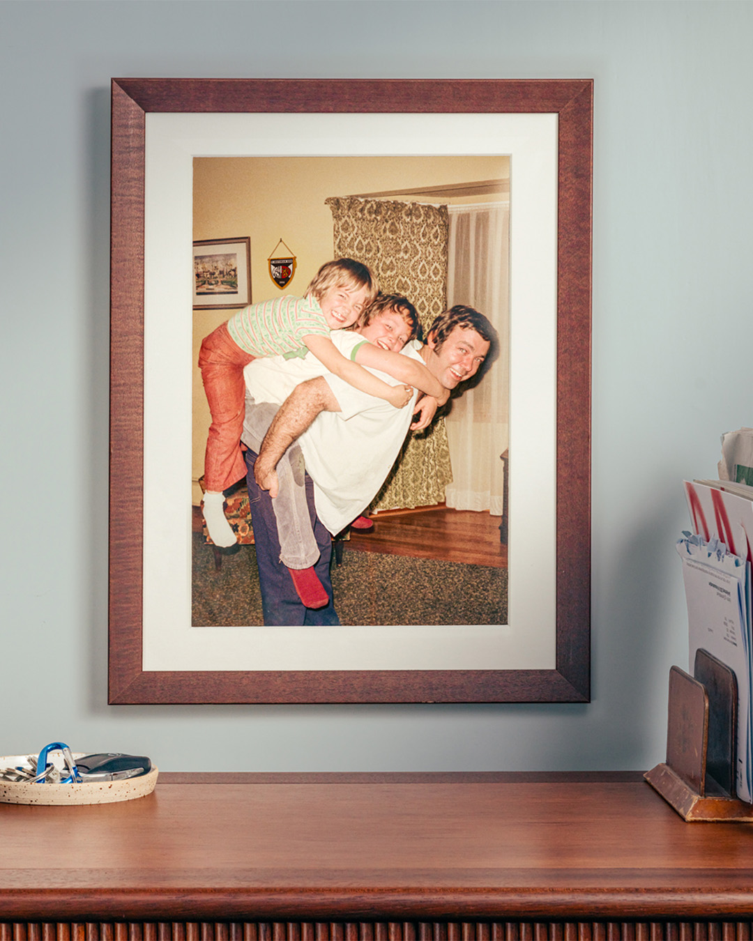 Die Kampagne «Heizt du immer noch wie damals?» für BEKB/myky in der Plakat-Anwendung. Ein Bild von ca. 1980 zeigt einen Familienvater, der seine beiden Kinder auf dem Rücken trägt.