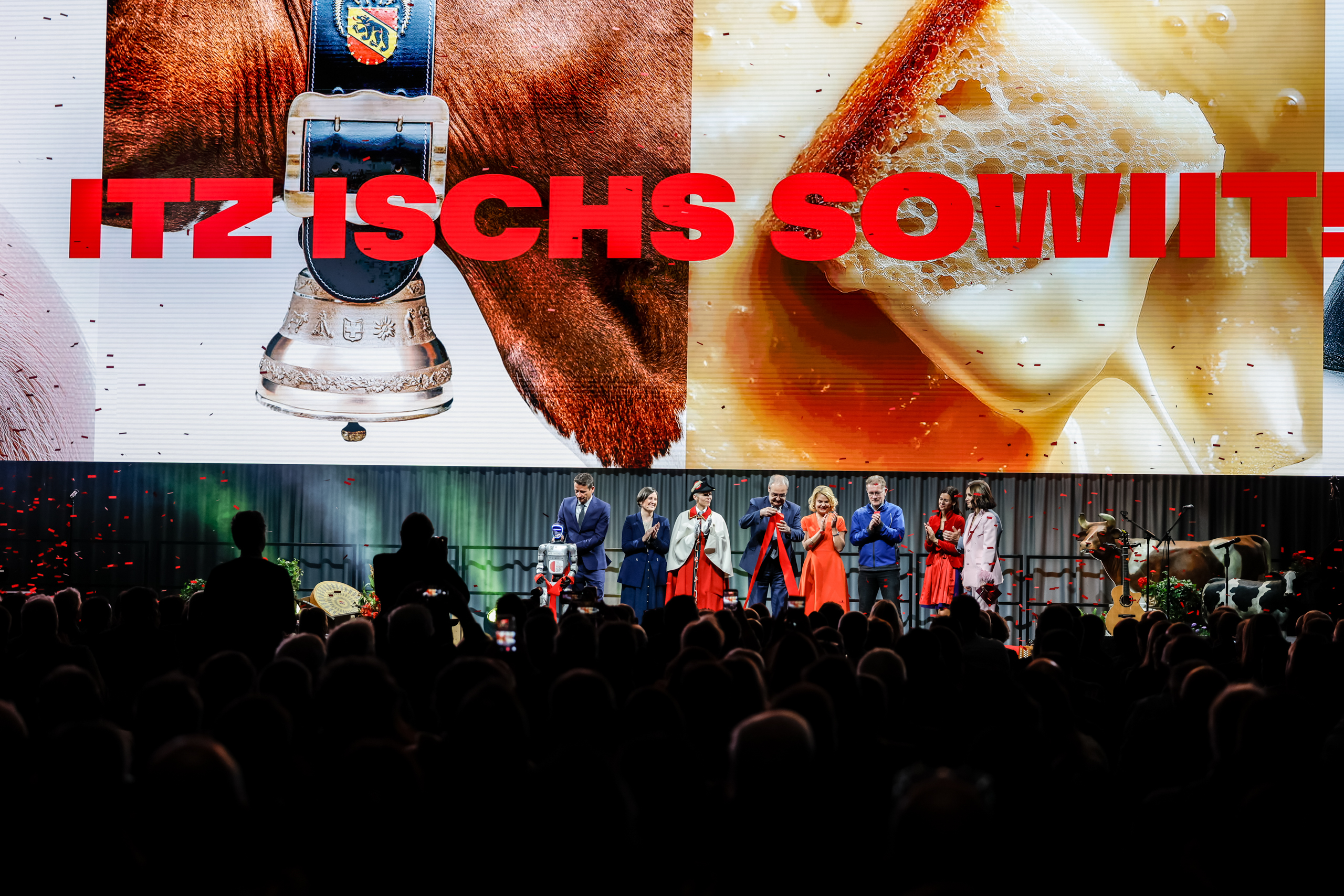 BEA-Eröffnung mit grosser Bühne und Publikum. Auf der LED-Wand sind Kampagnensujets mit Kuh, Käse und dem roten Schriftzug «Itz ischs sowit!» zu sehen.