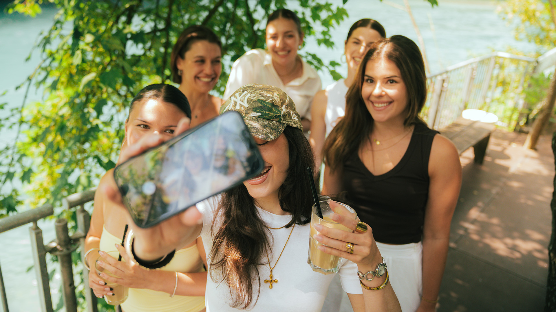 Junge Gruppe von Frauen machen gemeinsam ein Selfie auf einer Terrasse an der Aare.